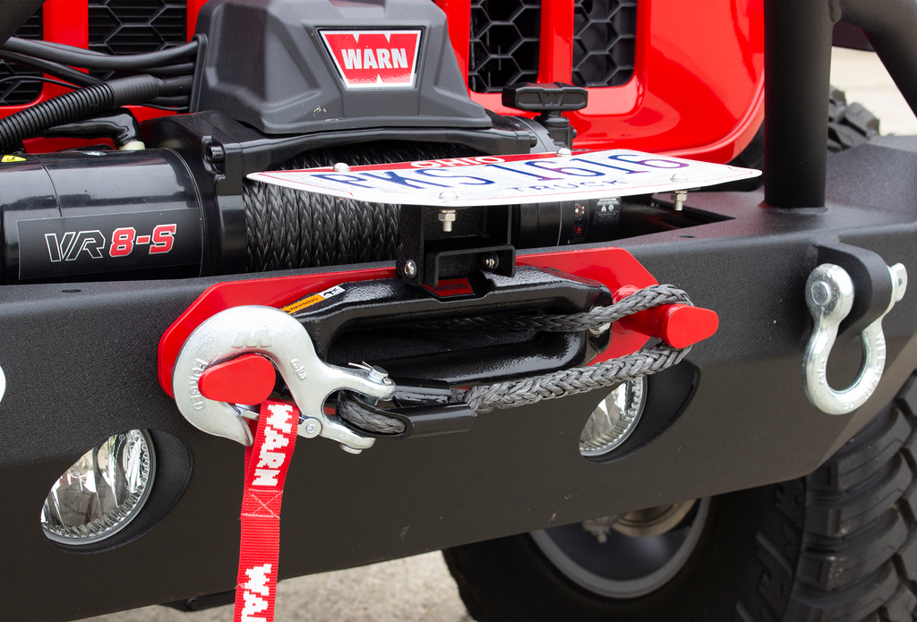 Fishbone Offroad black powder-coated fairlead license plate mount attached to a Hawse style fairlead, showcasing versatility and style.