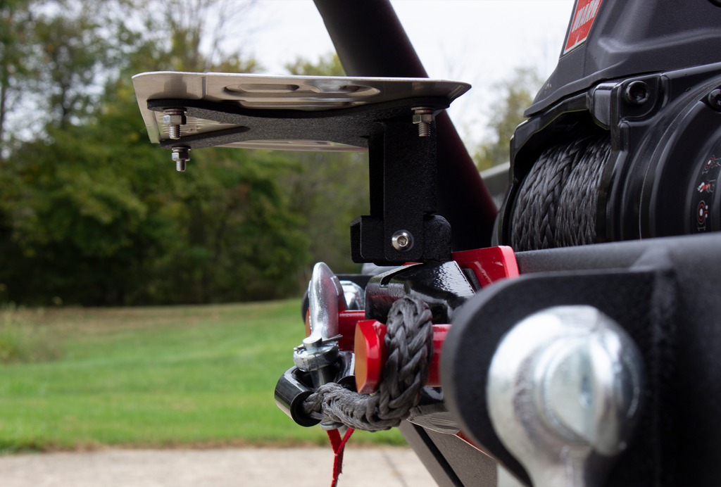 Fishbone Offroad black powder-coated fairlead license plate mount attached to a Hawse style fairlead, showcasing versatility and style.