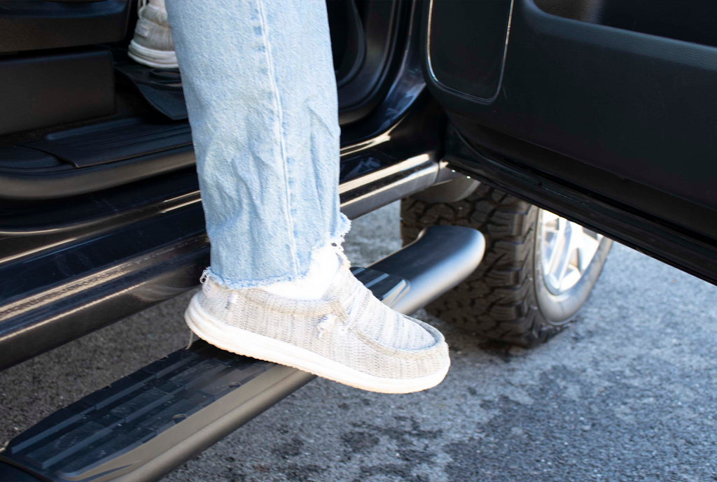 Fishbone's 5-inch oval side steps in black textured finish, designed for Ford Super Crew Cabs, showcasing the molded grip and fully welded dome ends