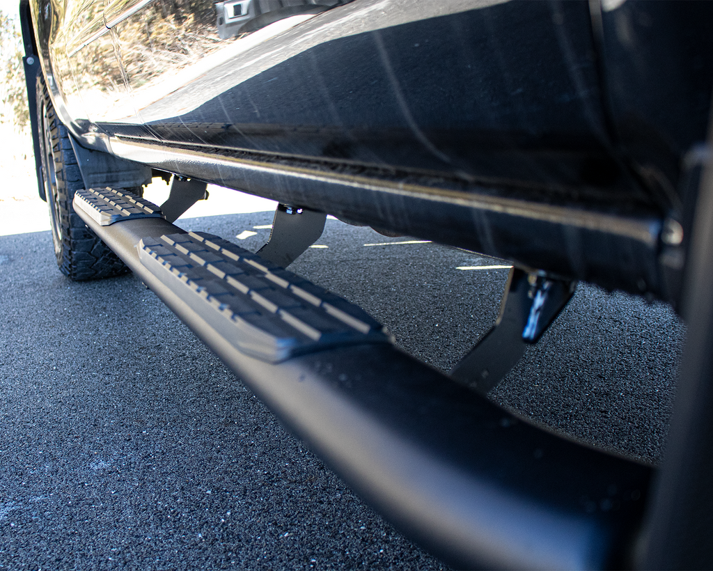 Robust 5-inch oval side steps with a distinct black textured finish, tailored for Chevrolet & GMC crew cab pickups, featuring a molded Fishbone grip step pad.