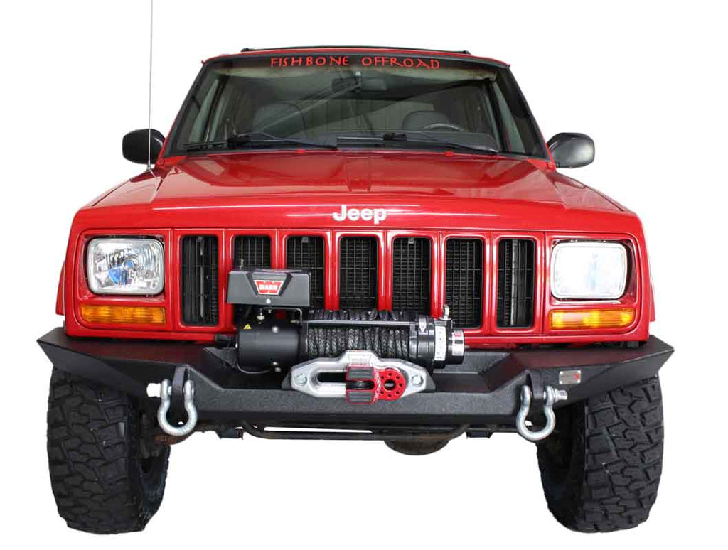 Jeep Cherokee XJ equipped with the Fishbone Offroad Bullhead Front Bumper, highlighting the bumper's sleek design and functionality in an off-road setting