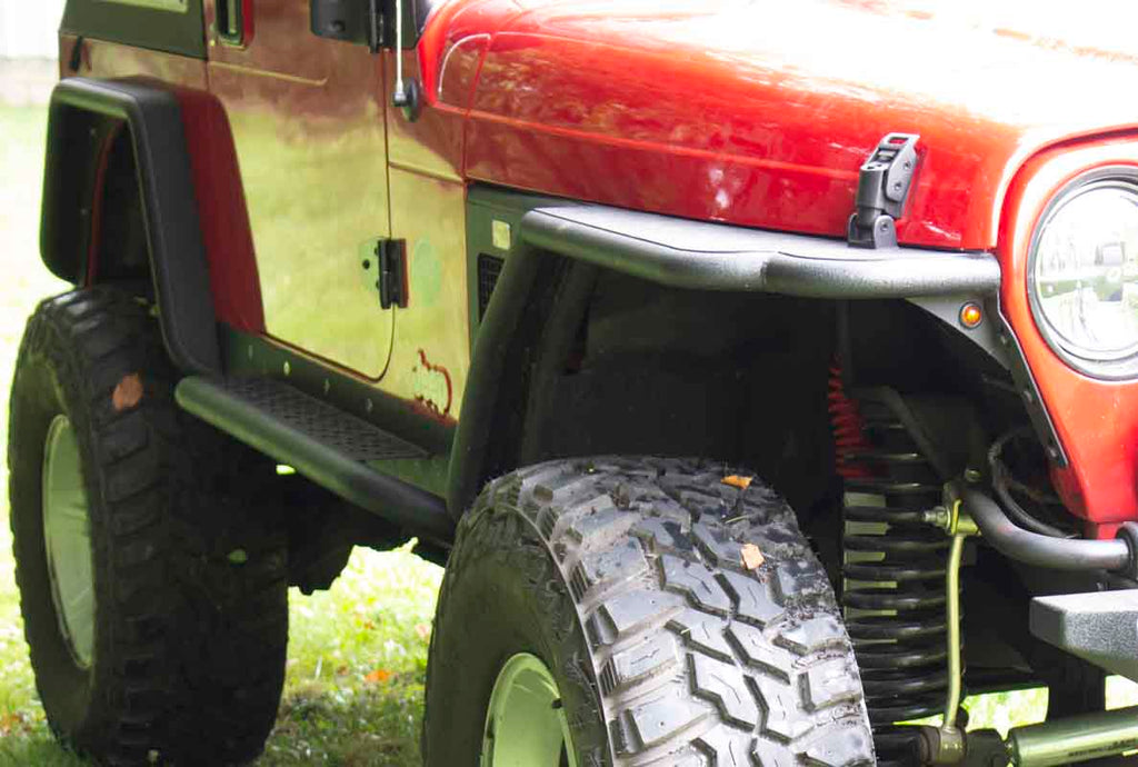 Fishbone Offroad Rock Sliders with a Tube Side Step, expertly crafted for Jeep Wrangler TJ, showcasing robust protection and elegant design.